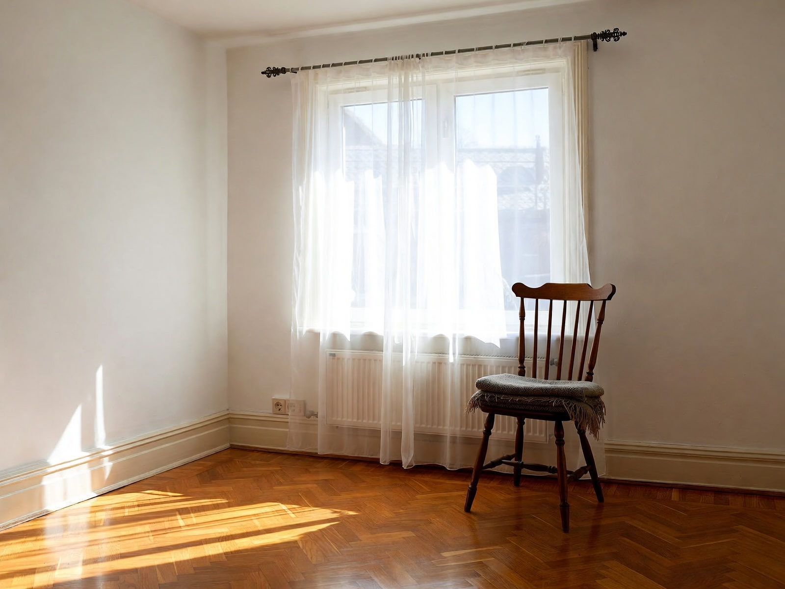 A quiet chair by a window in morning light